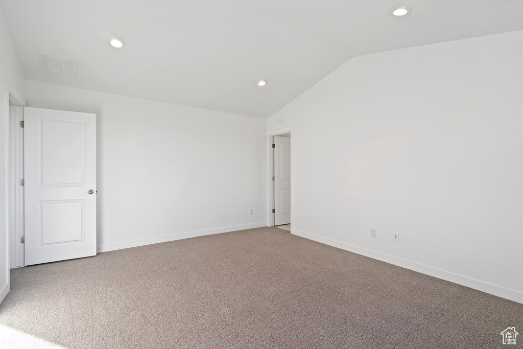 Carpeted spare room featuring lofted ceiling and recessed lighting