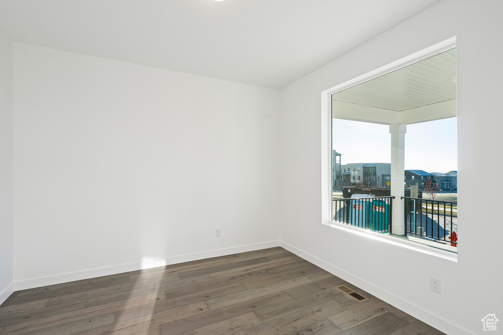 Unfurnished room with wood finished floors and baseboards