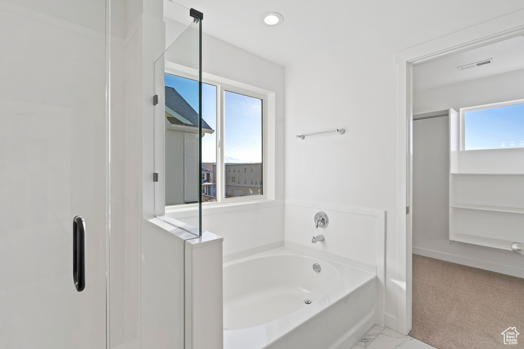 Bathroom with a bath, a shower stall, and marble finish floors