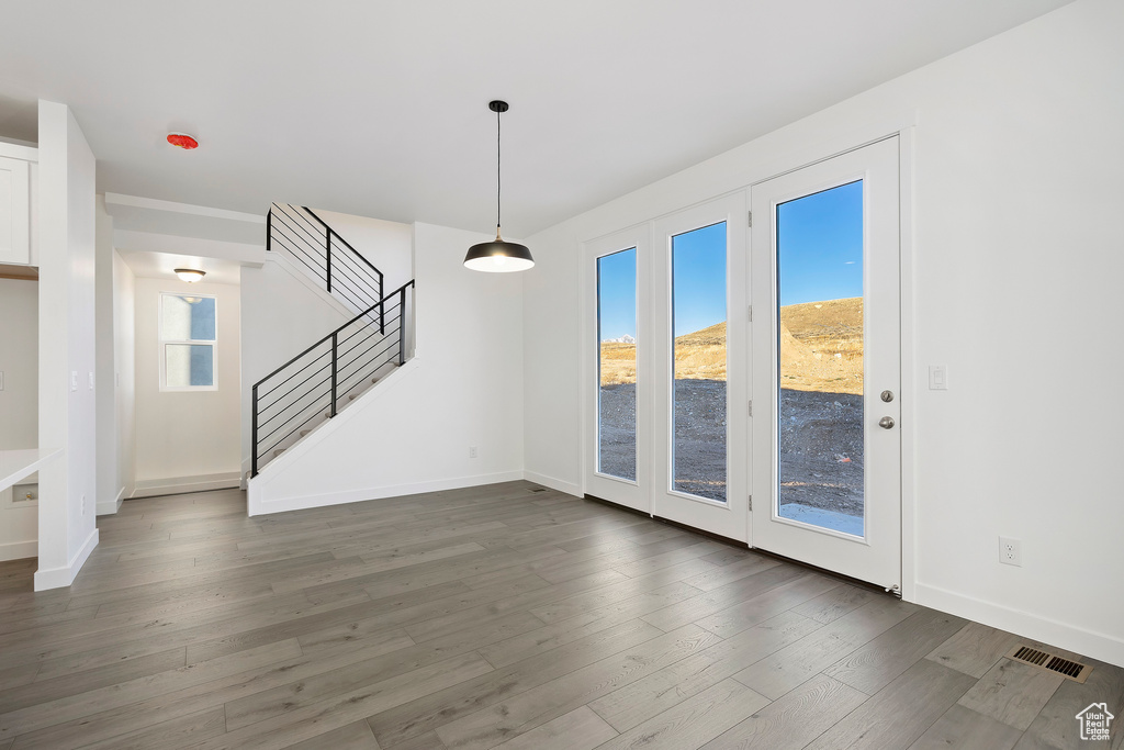 Unfurnished living room featuring stairway and wood finished floors