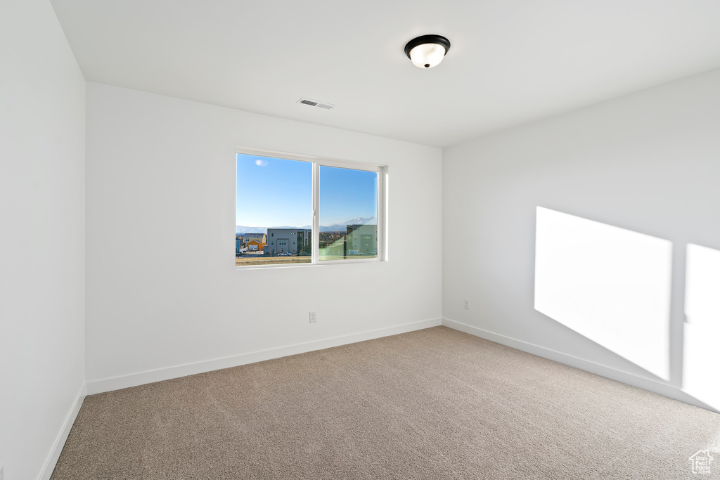 Carpeted empty room with baseboards