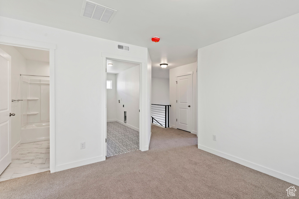 Unfurnished bedroom featuring carpet and connected bathroom