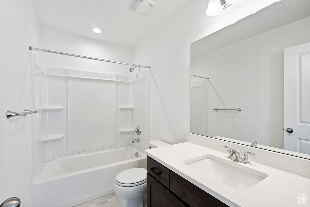 Full bathroom featuring vanity, shower / bath combination, marble look tile flooring, and recessed lighting