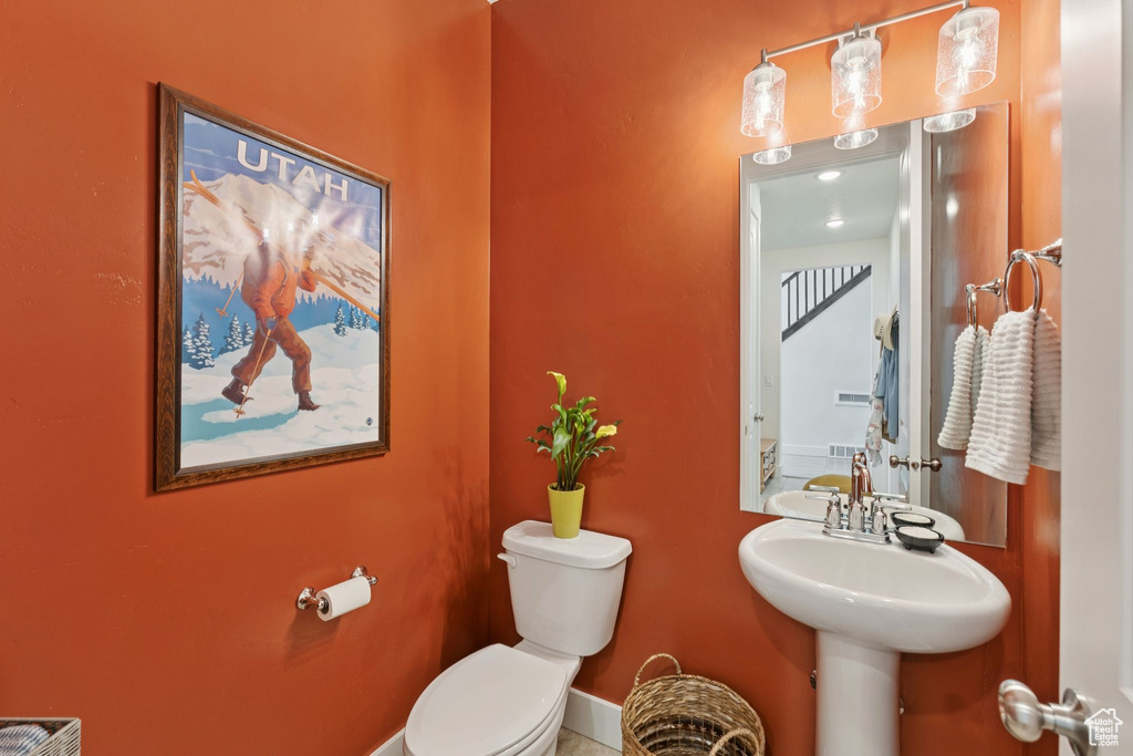 Half bathroom featuring toilet and baseboards
