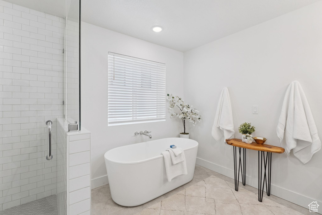 Bathroom featuring a stall shower and a soaking tub