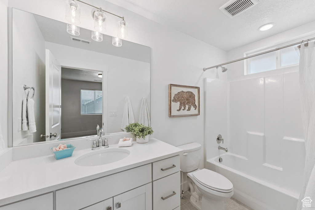 Full bath featuring vanity, shower / tub combo with curtain, and plenty of natural light