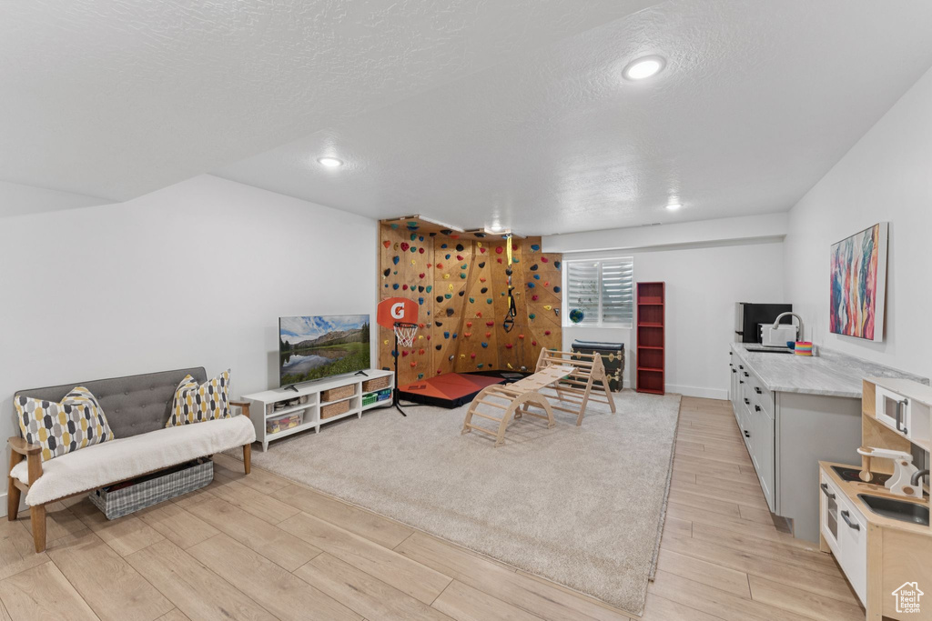 Living room featuring light wood-type flooring, recessed lighting, and a textured ceiling