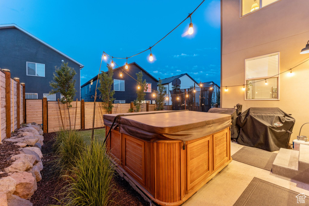 Yard at night featuring a hot tub