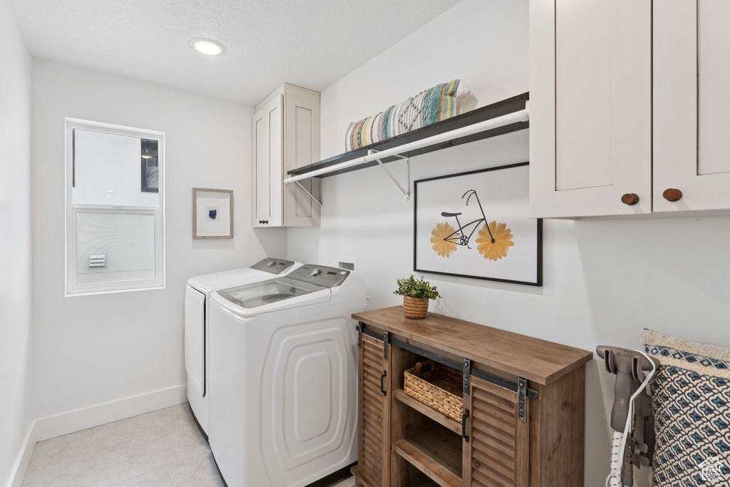 Washroom featuring washing machine and clothes dryer, cabinet space, and recessed lighting
