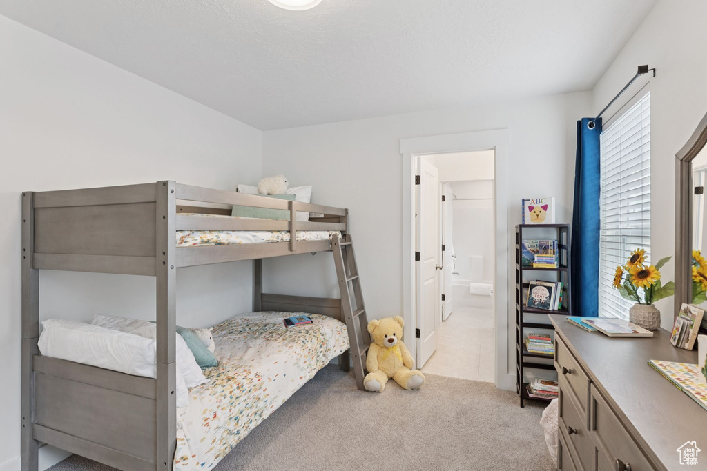 Carpeted bedroom featuring ensuite bathroom