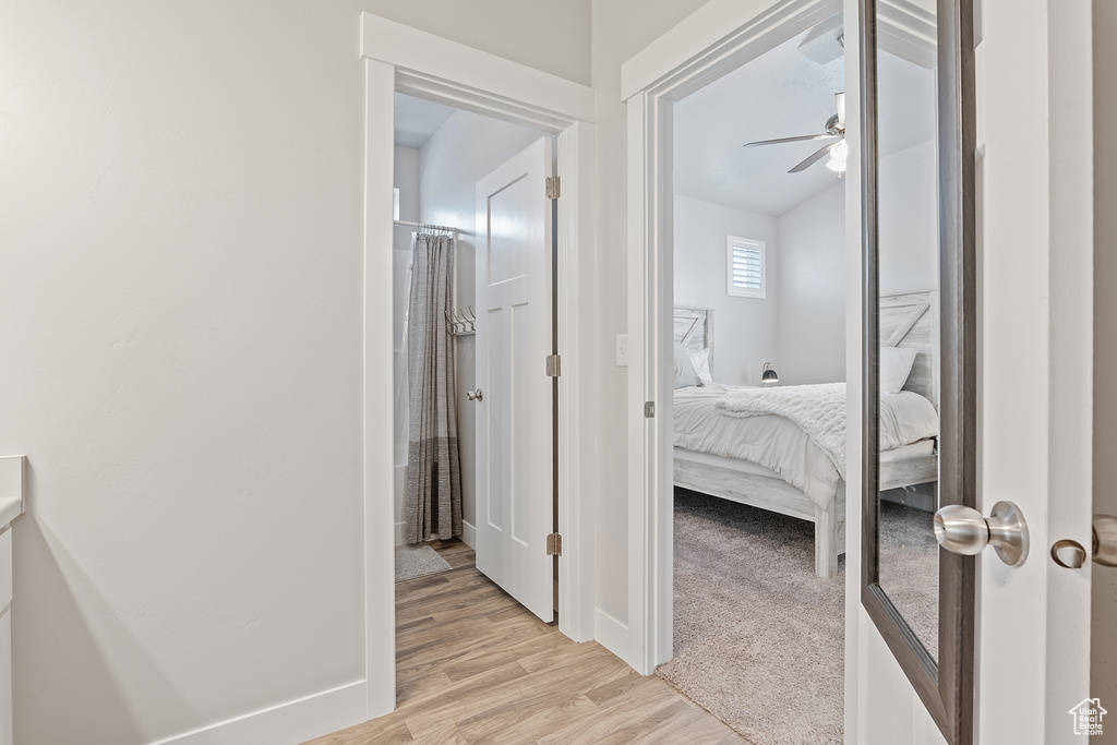 Corridor featuring light wood-style flooring and baseboards