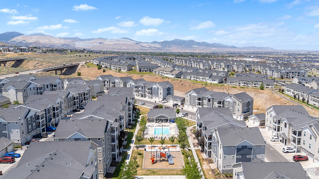 Aerial perspective of suburban area featuring a mountainous background and a pool