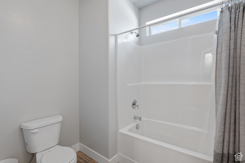 Full bath featuring shower / bath combination with curtain and wood finished floors