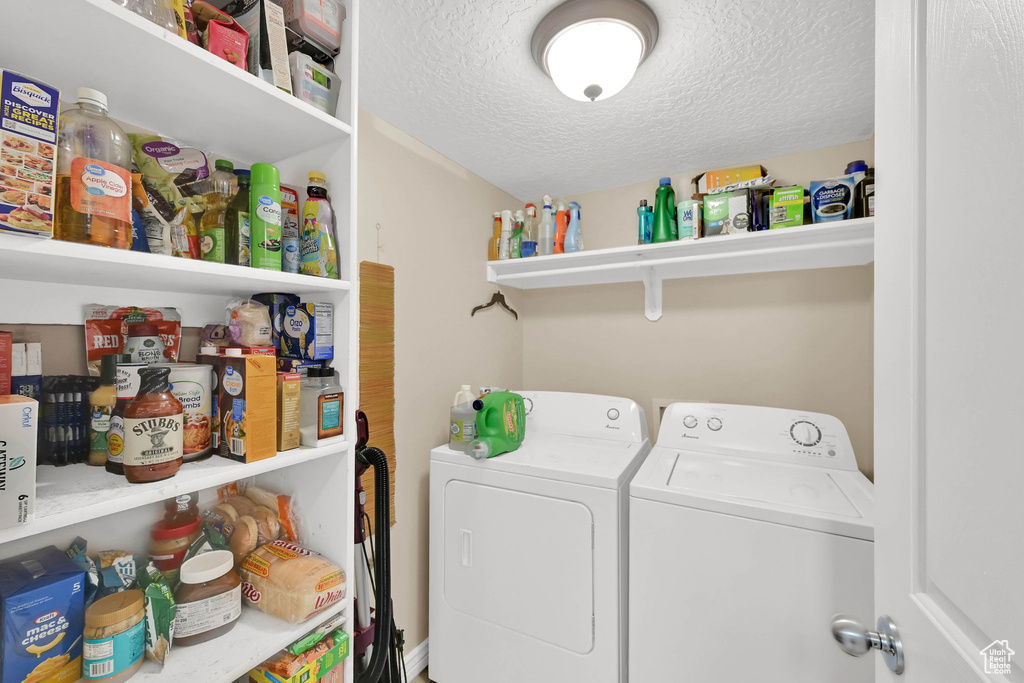 Laundry area with independent washer and dryer and a textured ceiling