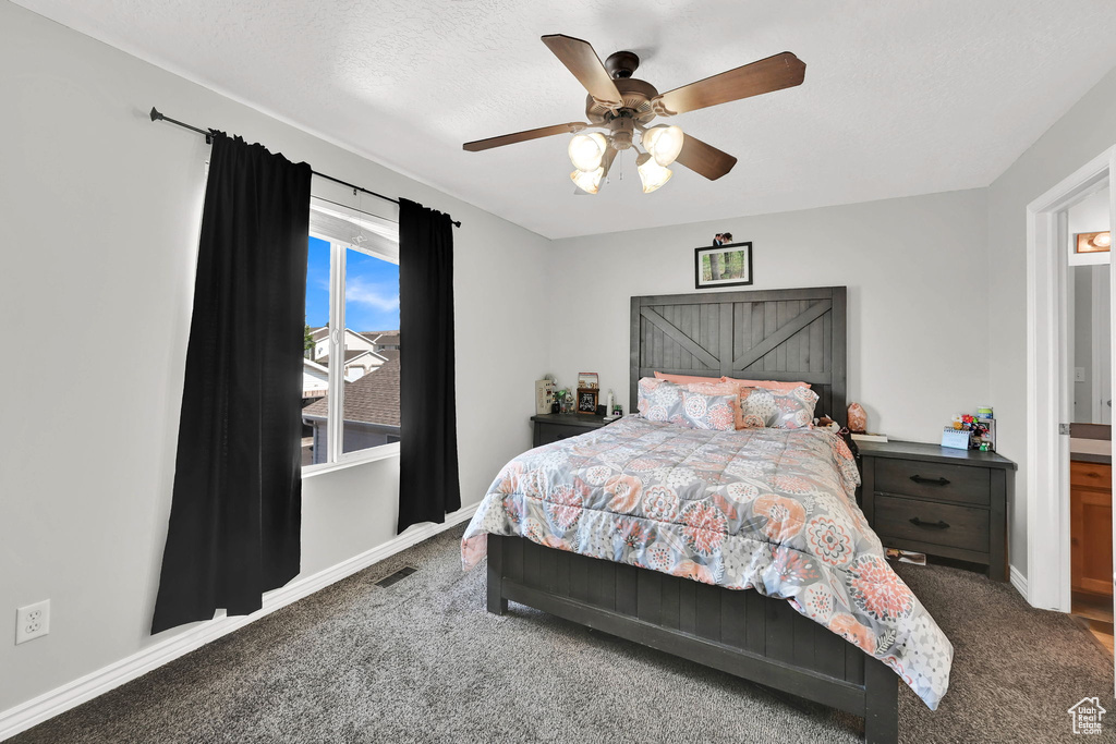 Carpeted bedroom featuring baseboards and a ceiling fan