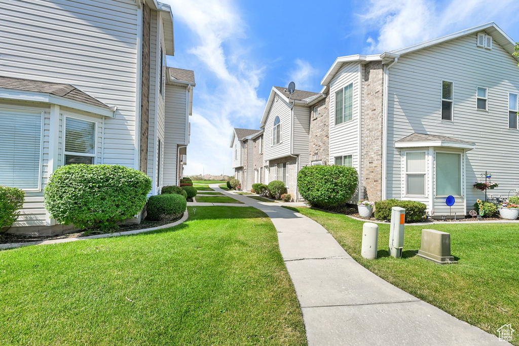 View of property's community featuring a lawn and a residential view