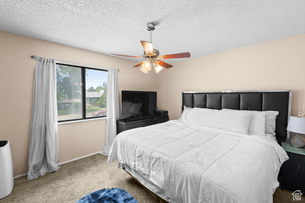 Bedroom with carpet flooring, a ceiling fan, and a textured ceiling