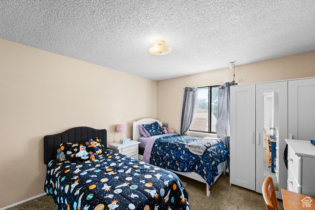 Carpeted bedroom featuring a textured ceiling