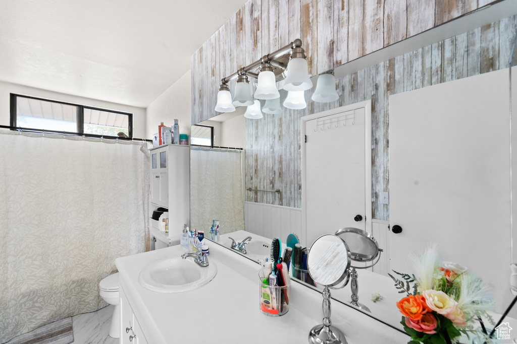 Bathroom with vanity, a chandelier, wallpapered walls, and marble finish floors