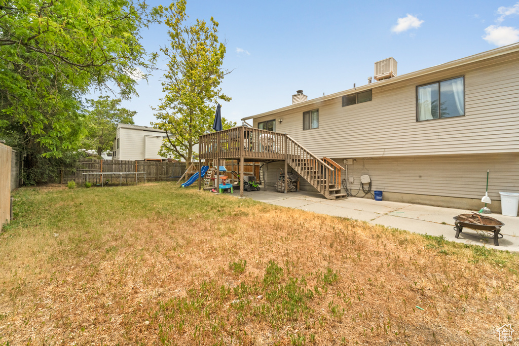 Rear view of house with a fenced backyard, a patio area, stairs, and a chimney