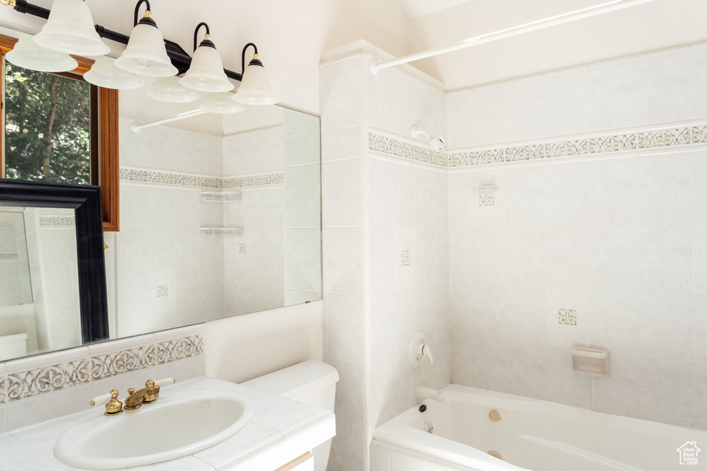 Full bath with vanity and tile walls