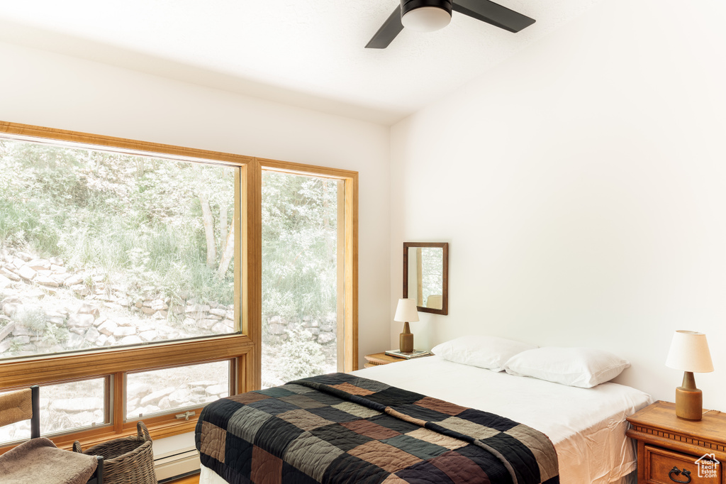 Bedroom with baseboard heating, a ceiling fan, and lofted ceiling