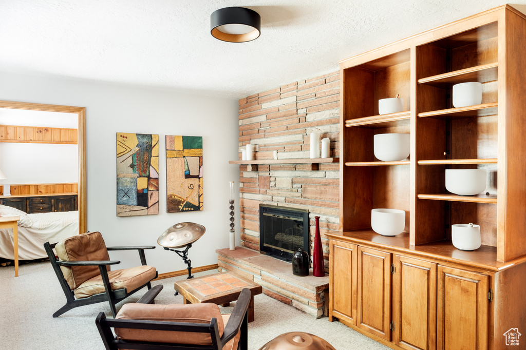 Living area featuring light carpet and a fireplace