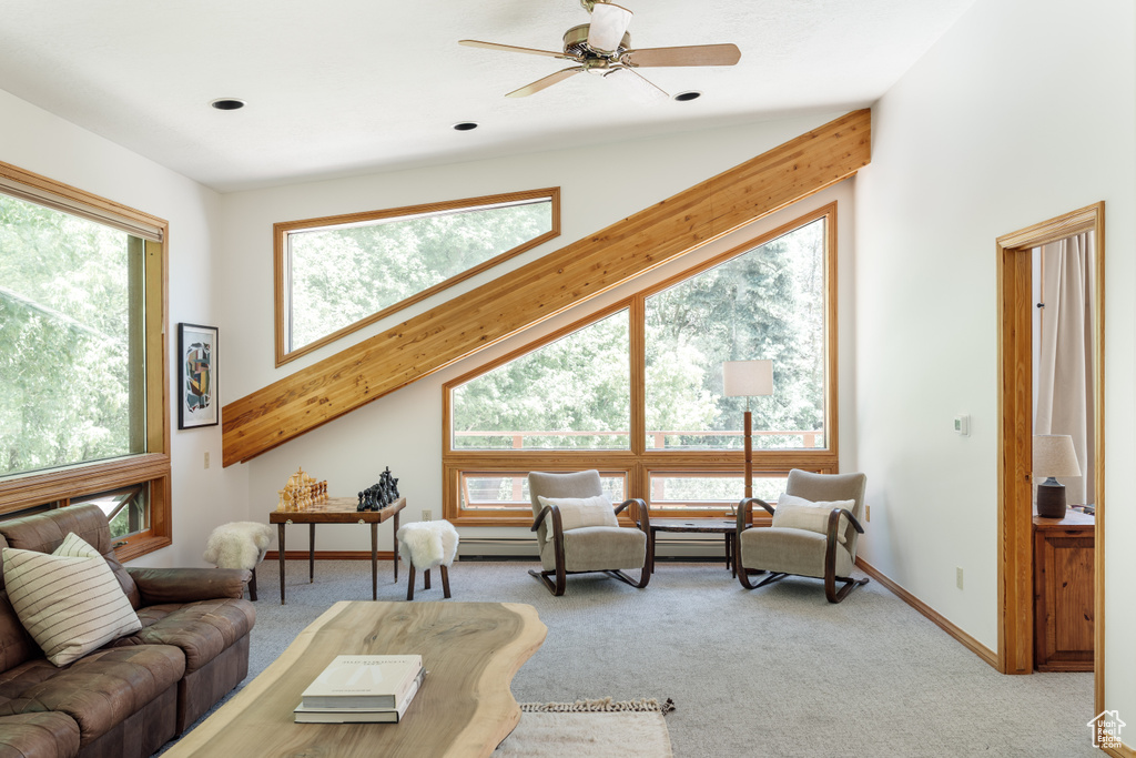 Living area featuring light colored carpet, a ceiling fan, and baseboard heating
