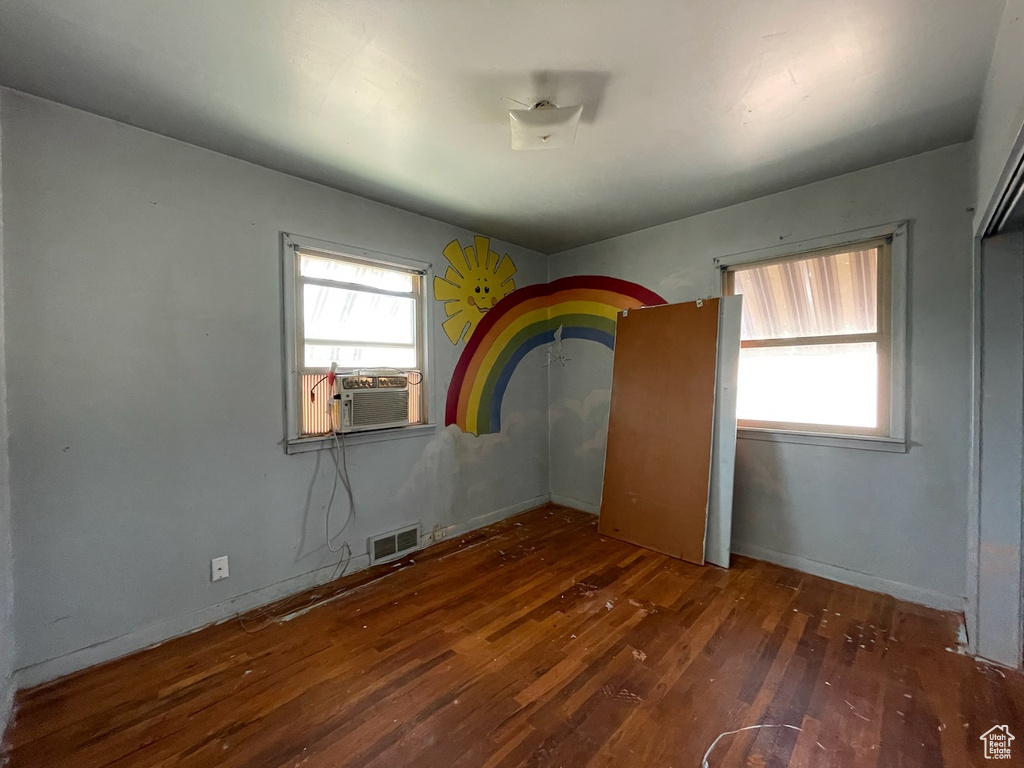 Unfurnished bedroom featuring cooling unit and wood-type flooring