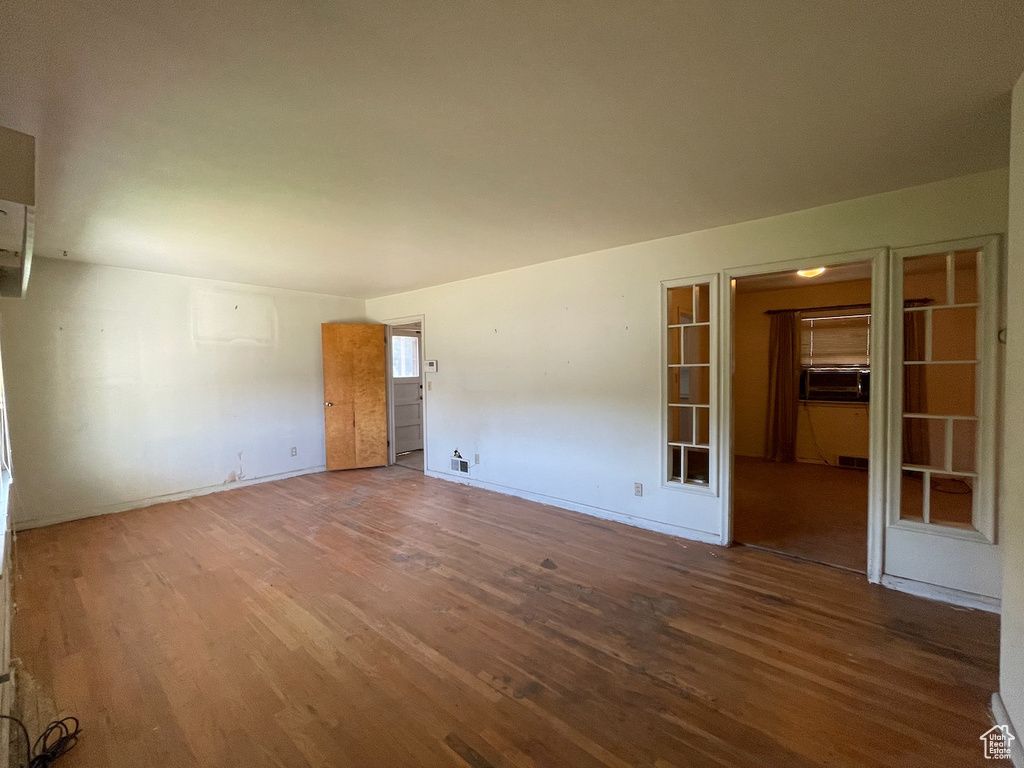 Empty room with wood finished floors and cooling unit
