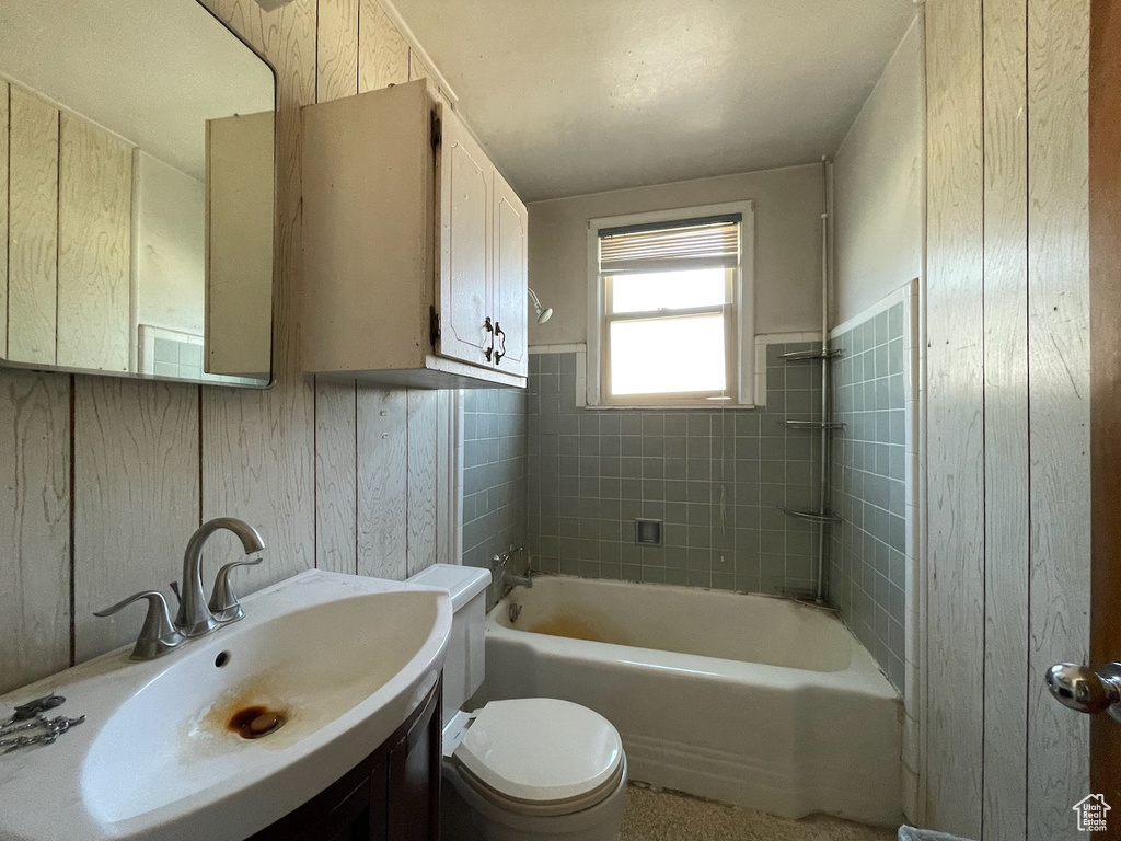 Bathroom featuring vanity, wainscoting, and washtub / shower combination