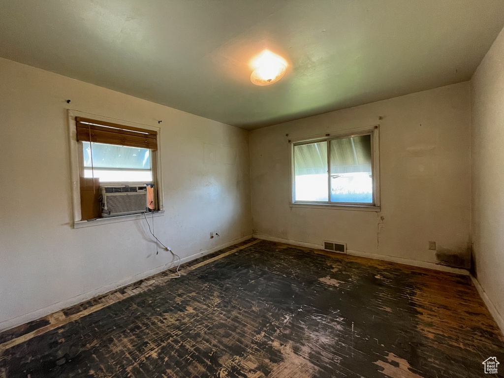 Empty room featuring cooling unit and baseboards