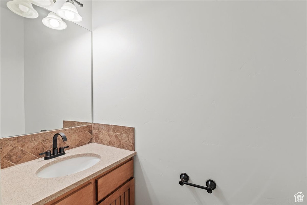 Bathroom with vanity and tasteful backsplash
