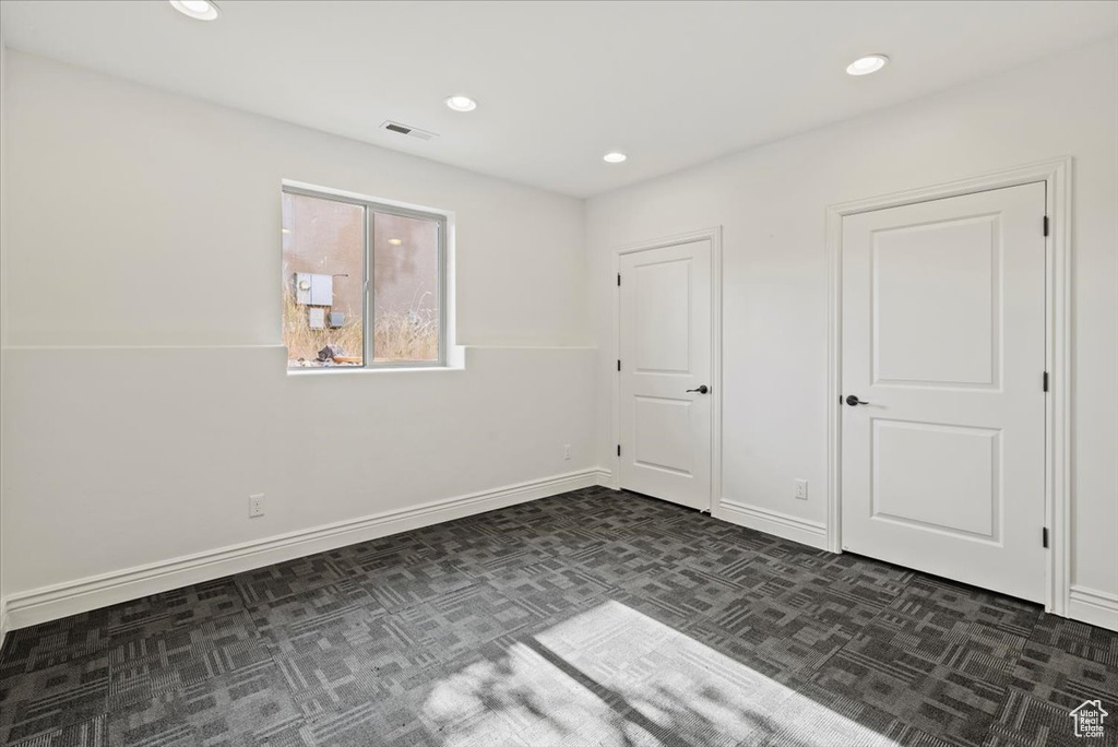 Unfurnished bedroom featuring dark carpet and recessed lighting