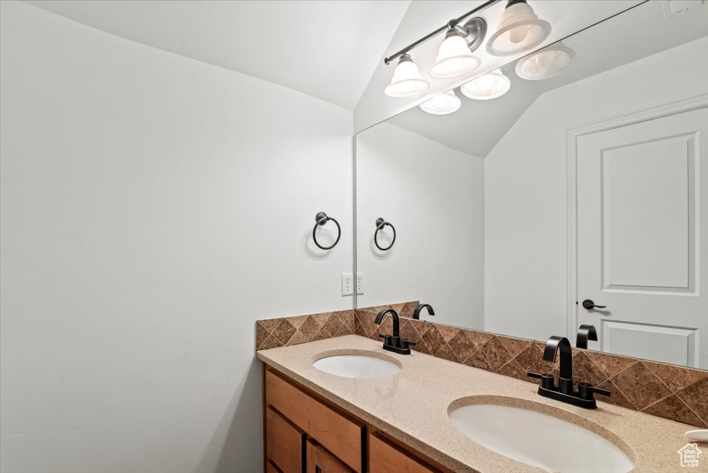 Full bath with double vanity and vaulted ceiling