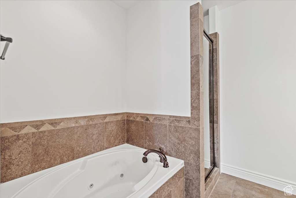 Bathroom featuring a jetted tub and a stall shower