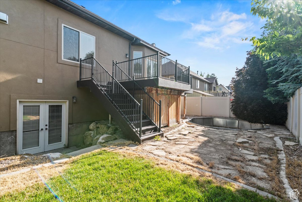 Rear view of property with stairway, french doors, and stucco siding