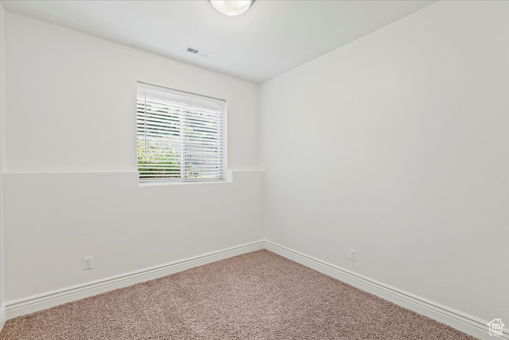 Carpeted empty room featuring baseboards