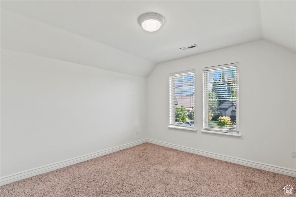 Additional living space featuring vaulted ceiling and carpet flooring