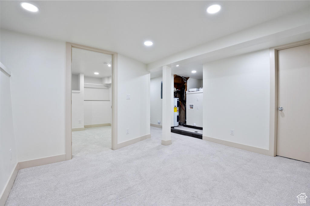 Finished basement featuring water heater, recessed lighting, and carpet