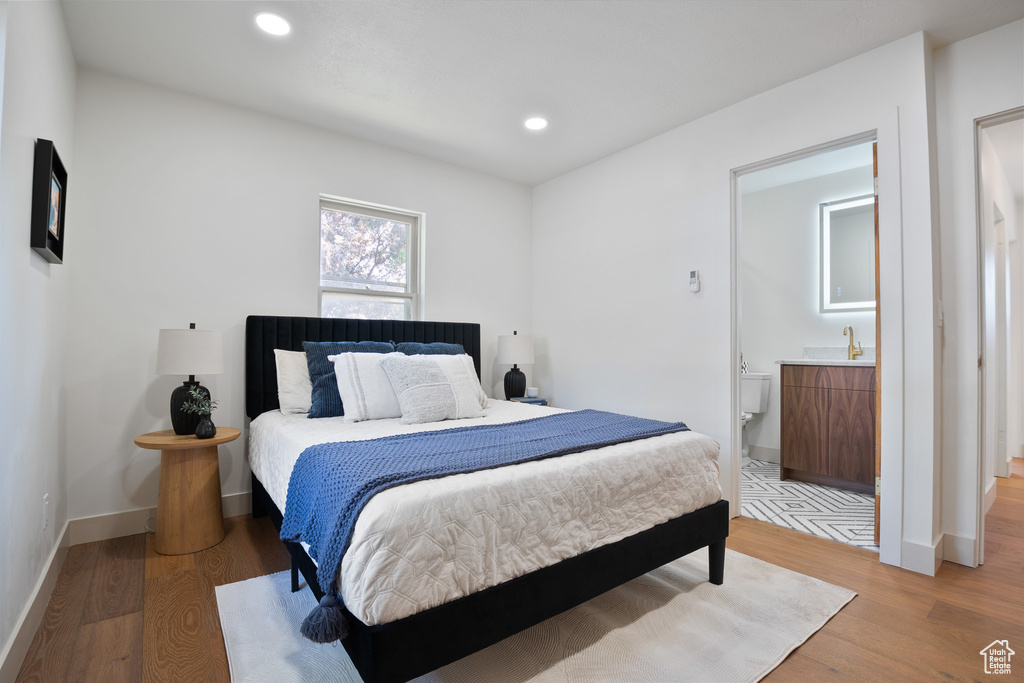 Bedroom featuring light wood-style flooring, recessed lighting, and ensuite bath