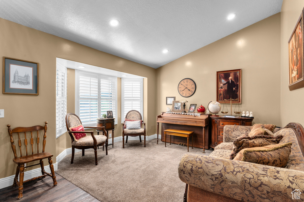 Living room with recessed lighting, wood finished floors, and lofted ceiling