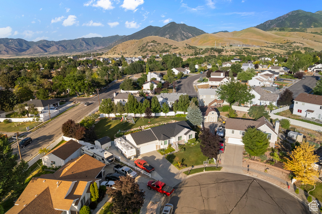 Aerial view of property and surrounding area with nearby suburban area and mountains