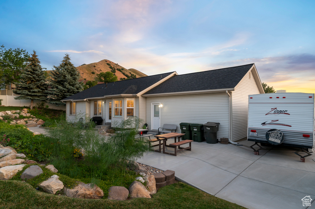 Back of house with a mountain view and a patio area