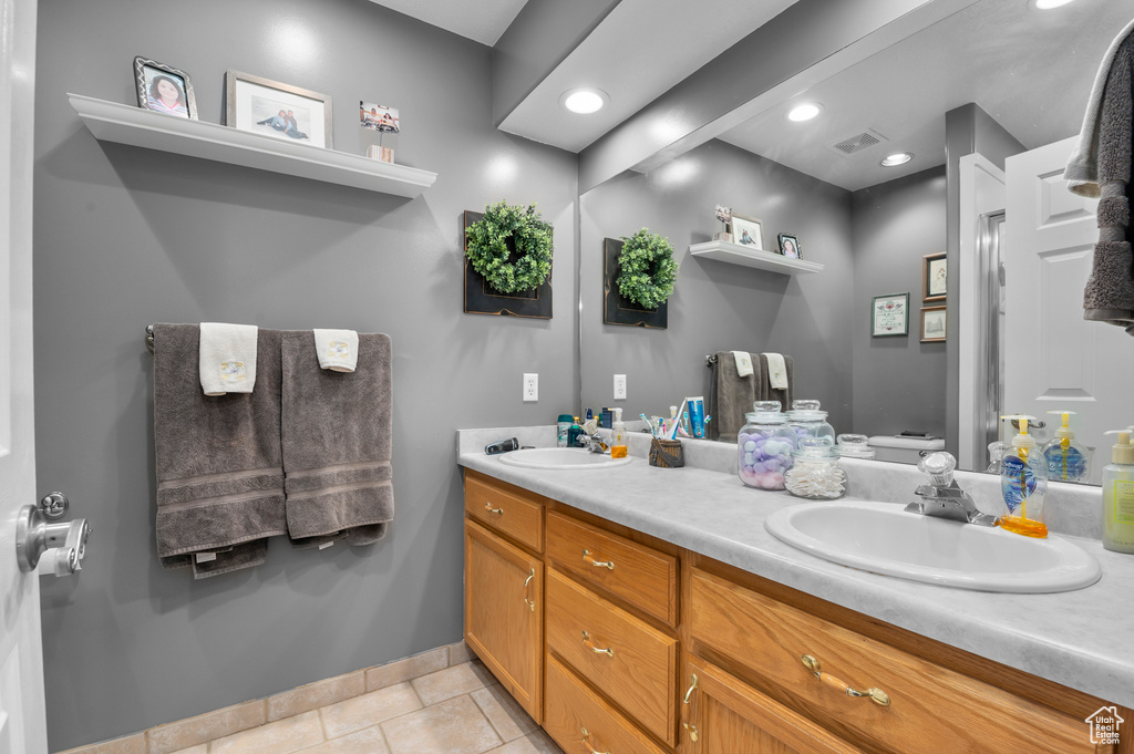 Bathroom with double vanity, tile patterned flooring, and recessed lighting