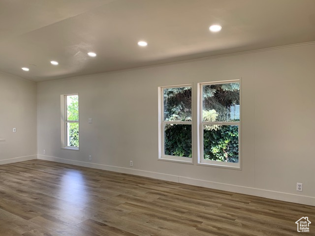 Spare room with crown molding, recessed lighting, and wood finished floors