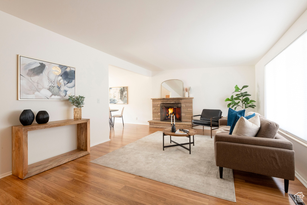 Living area with wood finished floors and a warm lit fireplace