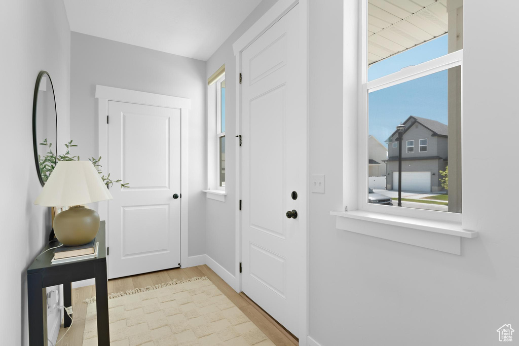 Doorway with wood finished floors and baseboards