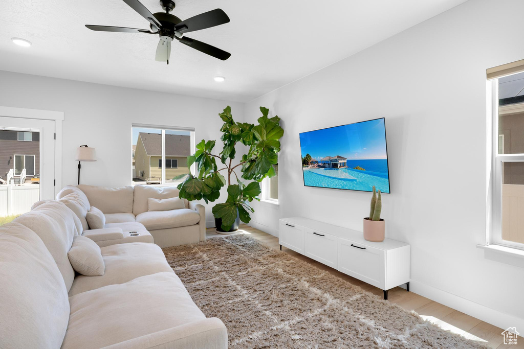 Living room with light wood-type flooring and a ceiling fan