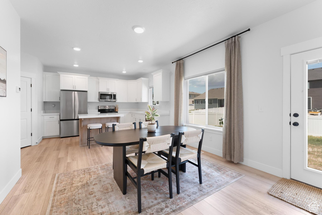 Dining space with light wood-style flooring and recessed lighting